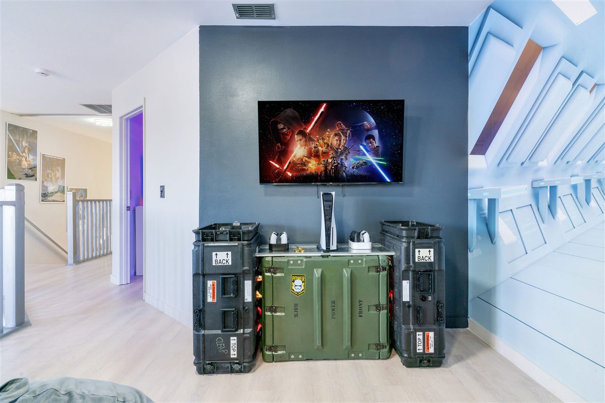 Themed entertainment center with mounted TV and gaming console in a Kahza vacation rental
